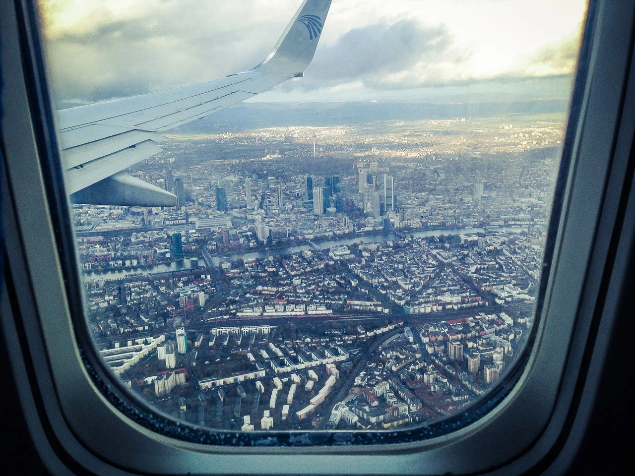 View of Frankfurt am Main, Germany through an airplane window, illustrating new transatlantic flight routes in 2026